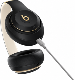 Beats Studio Pro Black and Gold headphones with USB-C cable connected